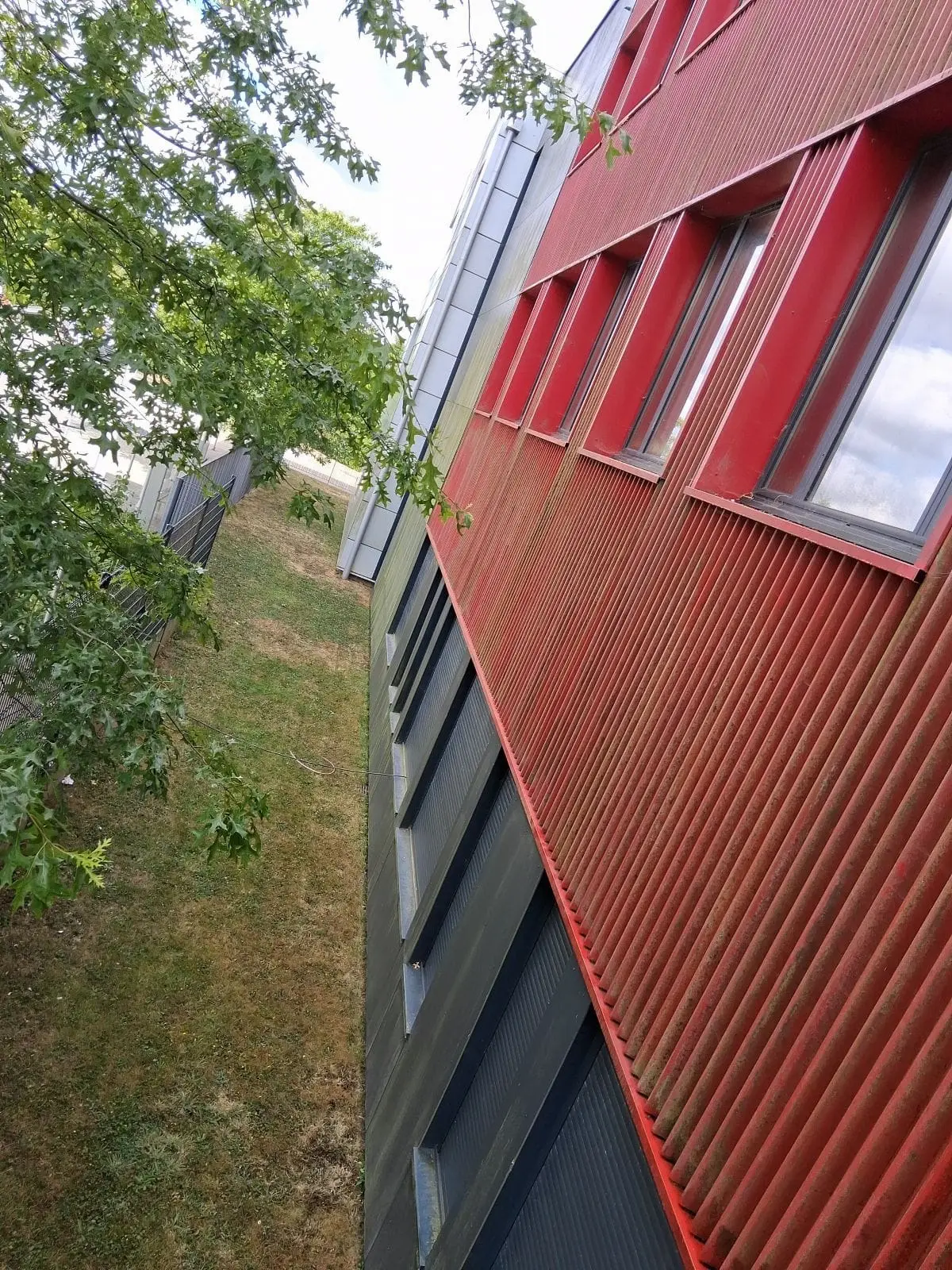 Bardage métallique rouge avant nettoyage avec salissures et pollution