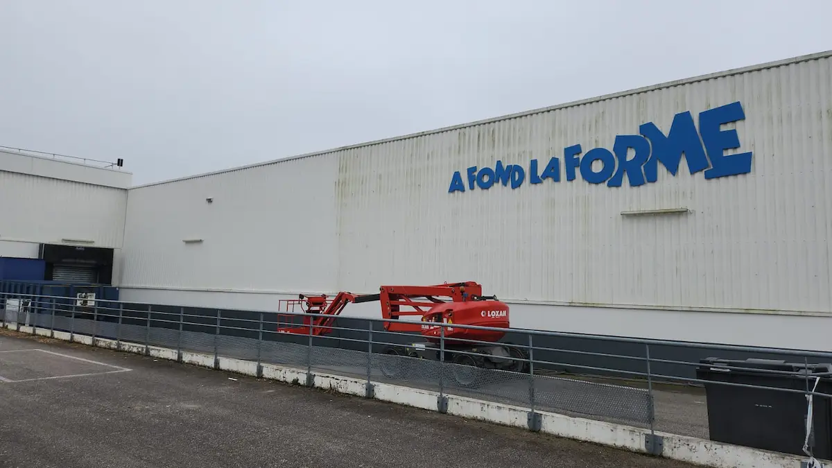 Nettoyage enseigne commerciale en cours avec nacelle par ECONET SOLUTION.